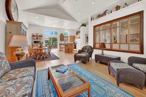 Living room featuring high vaulted ceiling and hardwood / wood-style flooring