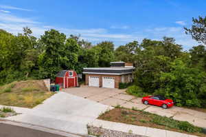 View of front of home featuring a garage and a shed