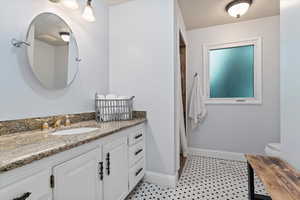 Bathroom with tile patterned floors, toilet, and vanity