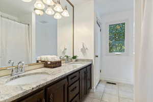 Bathroom with dual vanity and tile patterned floors