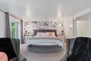 Bedroom with carpet floors, crown molding, and ornate columns