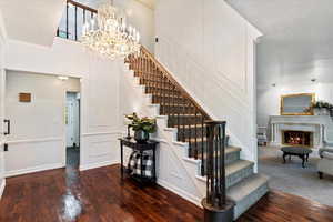 Stairway with a notable chandelier, ornamental molding, a textured ceiling, and hardwood / wood-style floors