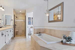 Full bathroom featuring tile patterned flooring, separate shower and tub, toilet, and vanity