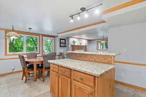 Kitchen with a center island, pendant lighting, track lighting, and light tile patterned floors