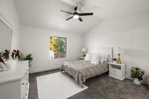 Carpeted bedroom featuring ceiling fan and vaulted ceiling