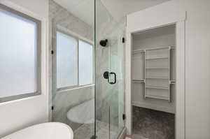 Bathroom featuring a wealth of natural light and separate shower and tub