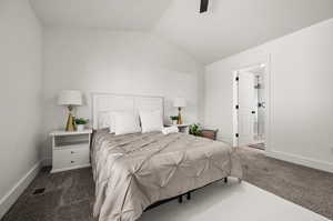 Bedroom with dark colored carpet, ensuite bath, lofted ceiling, and ceiling fan