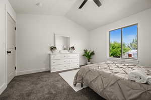 Carpeted bedroom featuring lofted ceiling and ceiling fan