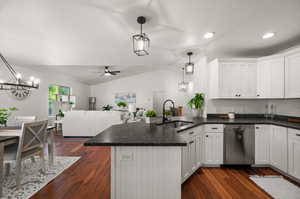 Kitchen featuring ceiling fan with notable chandelier, dark hardwood / wood-style flooring, stainless steel dishwasher, hanging light fixtures, and sink