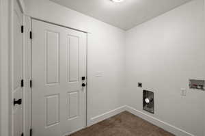 Washroom featuring hookup for a washing machine, hookup for an electric dryer, and dark tile patterned flooring