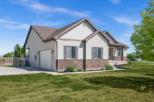 View of property exterior featuring a garage and a lawn