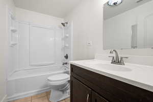 Full bathroom with tile patterned floors, toilet, vanity, and tub / shower combination