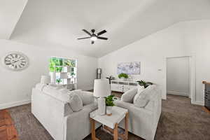 Living room featuring dark hardwood / wood-style floors, ceiling fan, and lofted ceiling