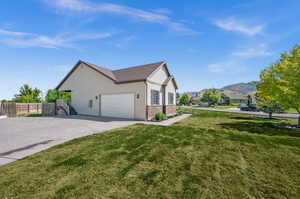 View of property exterior featuring a lawn and a mountain view