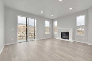 Unfurnished living room with a mountain view and light hardwood / wood-style floors