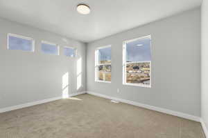 Unfurnished room featuring light colored carpet and a textured ceiling