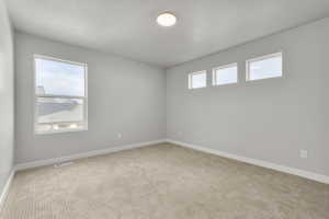 Carpeted empty room with a textured ceiling