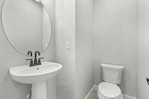 Bathroom featuring hardwood / wood-style flooring, sink, and toilet