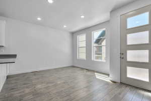 Unfurnished dining area with a healthy amount of sunlight and dark hardwood / wood-style floors