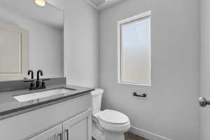 Bathroom featuring hardwood / wood-style floors, vanity, and toilet