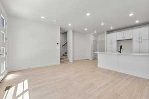 Unfurnished living room featuring light hardwood / wood-style floors and sink