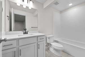 Full bathroom featuring vanity, shower / bath combination, and toilet