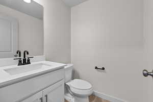 Bathroom with wood-type flooring, toilet, and vanity