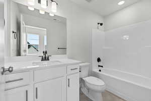 Full bathroom featuring tile patterned flooring, washtub / shower combination, toilet, and vanity