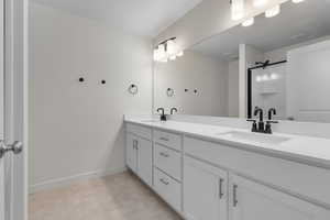 Bathroom with tile patterned flooring and dual bowl vanity