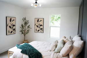 Bedroom featuring a chandelier and carpet