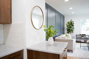 Kitchen featuring decorative backsplash, light hardwood / wood-style floors, and light stone countertops