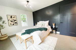 Carpeted bedroom featuring a notable chandelier