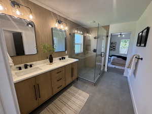 Bathroom featuring tile patterned flooring, an enclosed shower, and dual bowl vanity