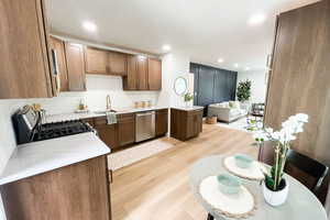 Kitchen featuring sink, appliances with stainless steel finishes, light hardwood / wood-style flooring, and tasteful backsplash