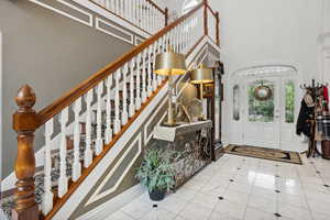 Tiled entrance foyer featuring a towering ceiling