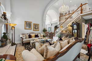 Tiled living room featuring an inviting chandelier and a high ceiling