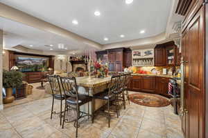 Dining area with light tile patterned flooring and a tray ceiling