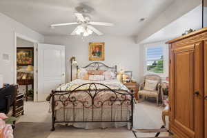 Carpeted bedroom featuring ceiling fan