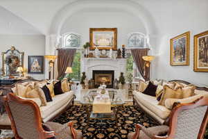 Living room featuring a tile fireplace, a healthy amount of sunlight, and vaulted ceiling