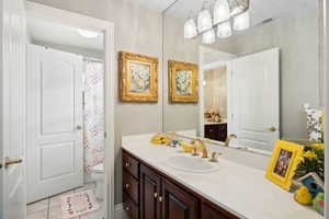 Bathroom featuring vanity, tile patterned flooring, and toilet