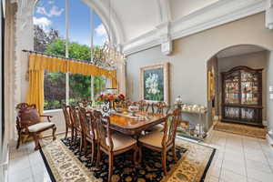 Tiled dining space featuring a notable chandelier