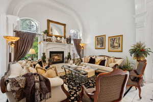 Tiled living room with a tiled fireplace, decorative columns, and a high ceiling