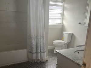 Full bathroom featuring toilet, vanity, and shower / tub combo with curtain