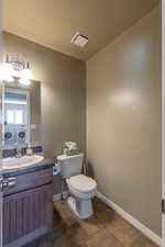 Bathroom featuring vanity, toilet, and tile patterned flooring