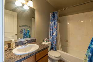 Full bathroom featuring vanity, toilet, and shower / bath combination with curtain