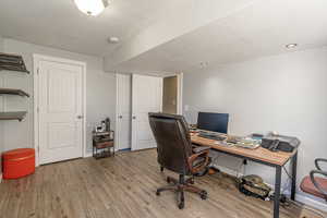 Office space featuring wood-type flooring and a textured ceiling