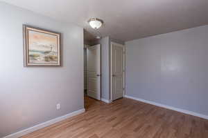 Unfurnished bedroom featuring a textured ceiling and light hardwood / wood-style floors