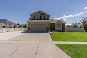 View of front facade featuring a garage and a front yard