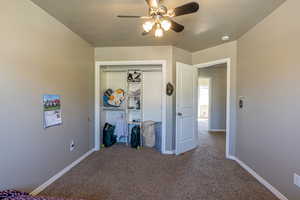 Unfurnished bedroom with a closet, carpet floors, and ceiling fan