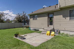 Exterior space with a trampoline, a patio, and a yard